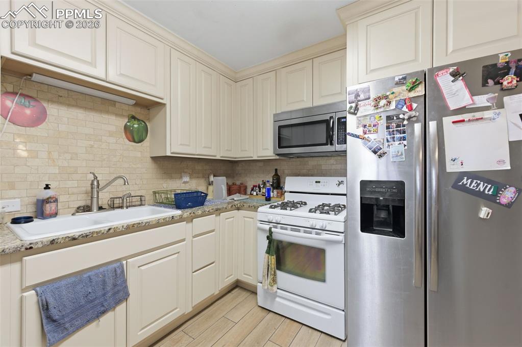 Image 12 of 24: Kitchen featuring light-toned cabinetry, granite-finish countertops, and a 