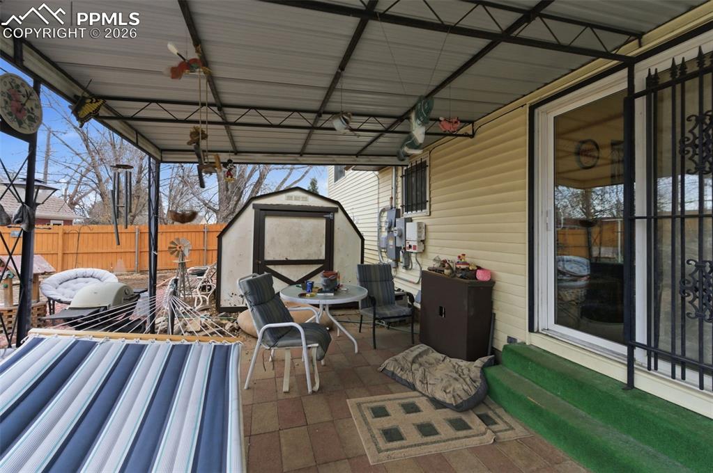 Image 20 of 24: Covered patio featuring a metal roof structure, paver flooring, and direct 