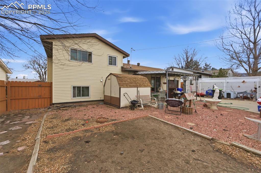 Image 24 of 24: Backyard featuring a vinyl-sided two-story residence with a brown privacy f