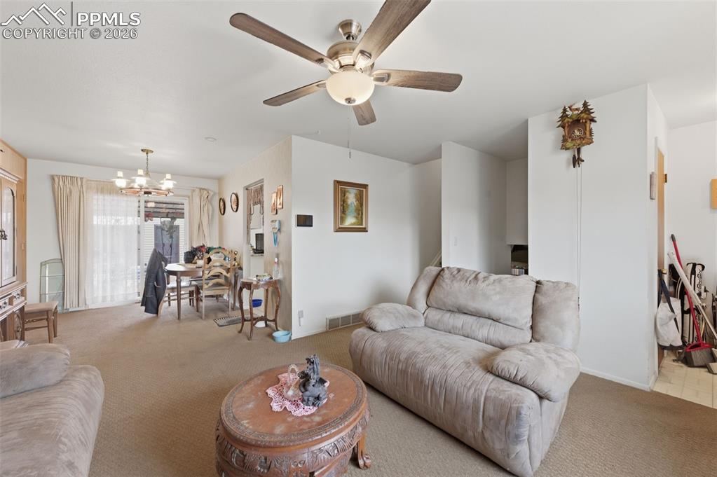 Image 6 of 24: Carpeted living area featuring a ceiling fan with integrated lighting, whit