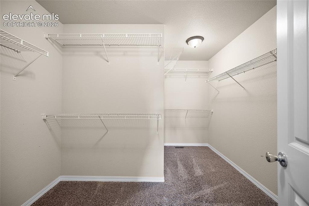 Image 22 of 38: Primary walk-in closet 