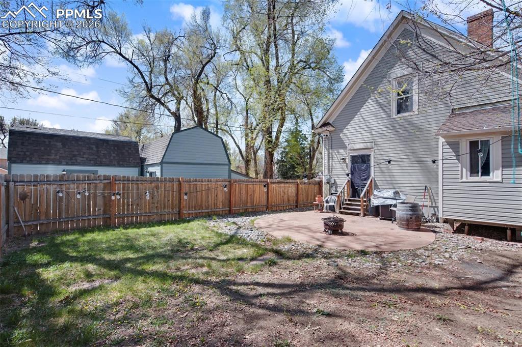 Image 4 of 14: Rear side of home and backyard + concrete patio