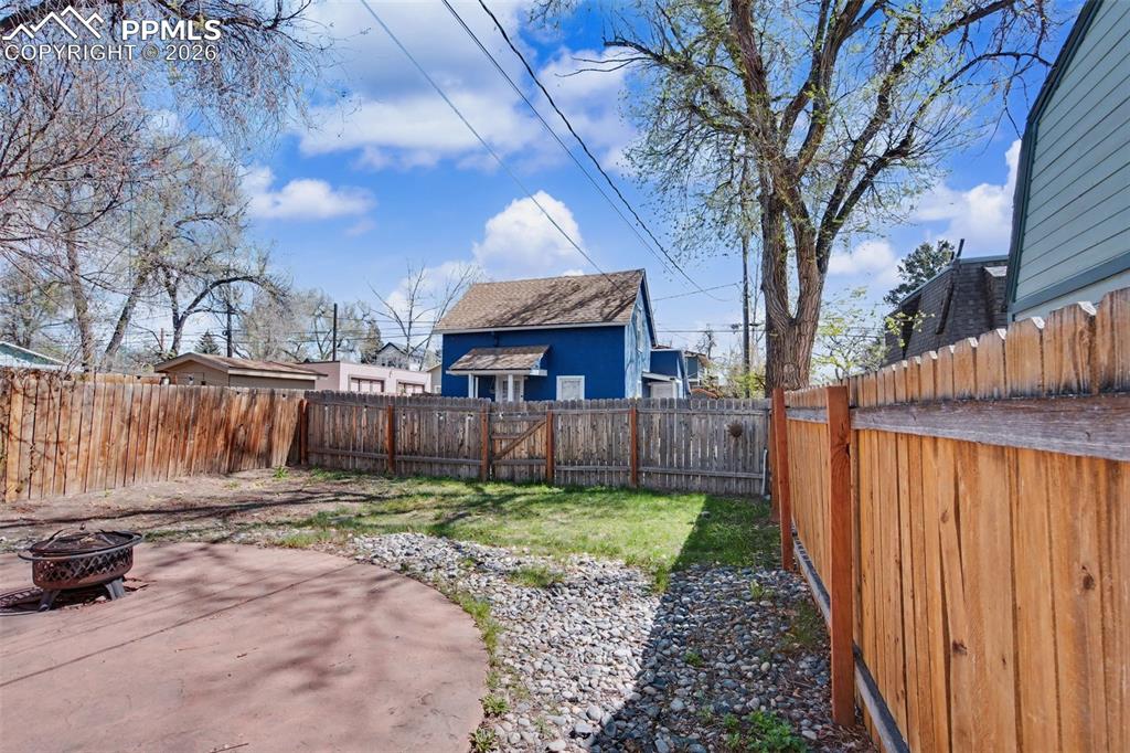 Image 6 of 14: Back yard of front house facing east and view of cottage house