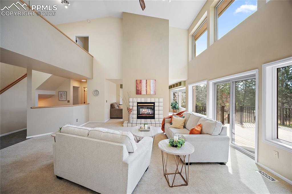 Image 10 of 49: Living room features gas fireplace, walk out to back deck and open to the f