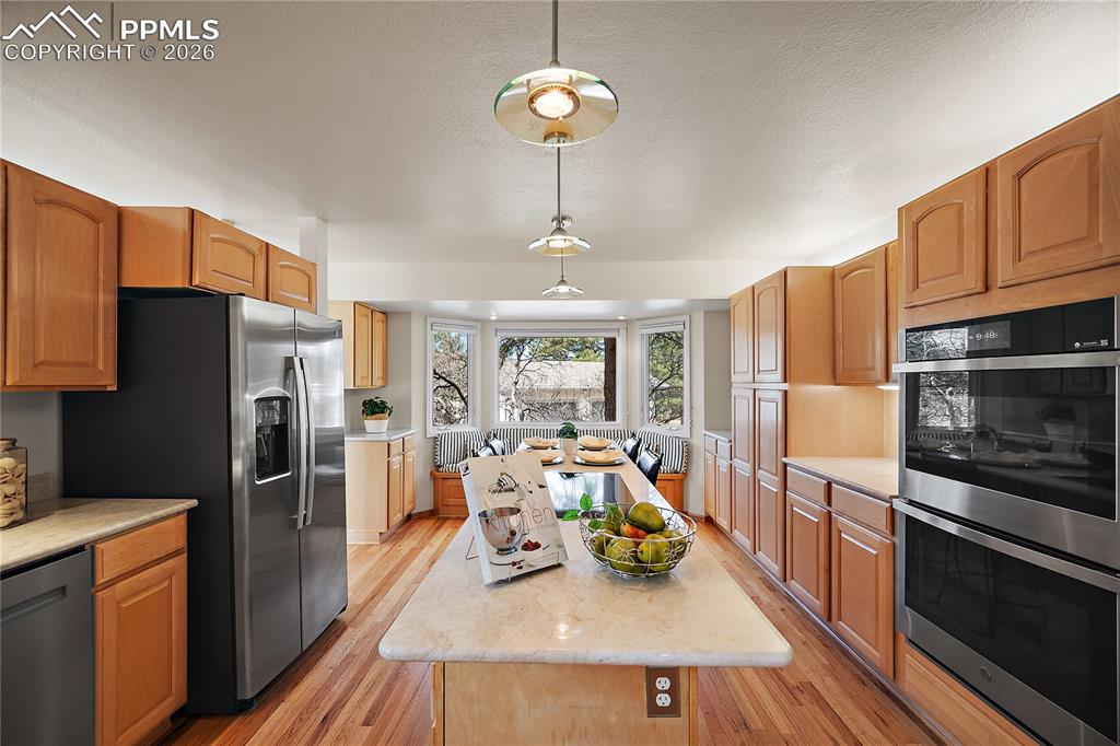 Image 17 of 49: Double oven, large island with cooktop.