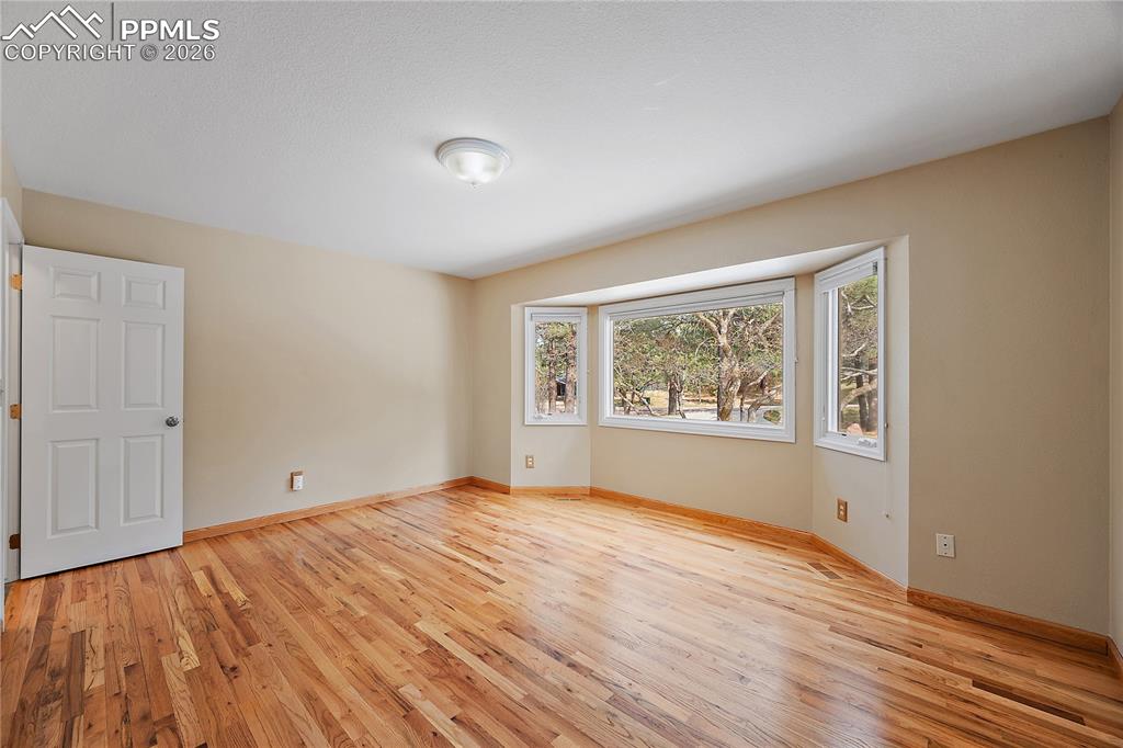 Image 20 of 49: Main level guest bedroom with hardwood flooring.