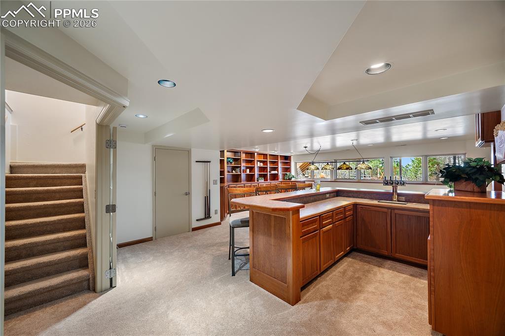 Image 31 of 49: Wet bar with 4 beer taps, built in bookcase and tons of windows for natural