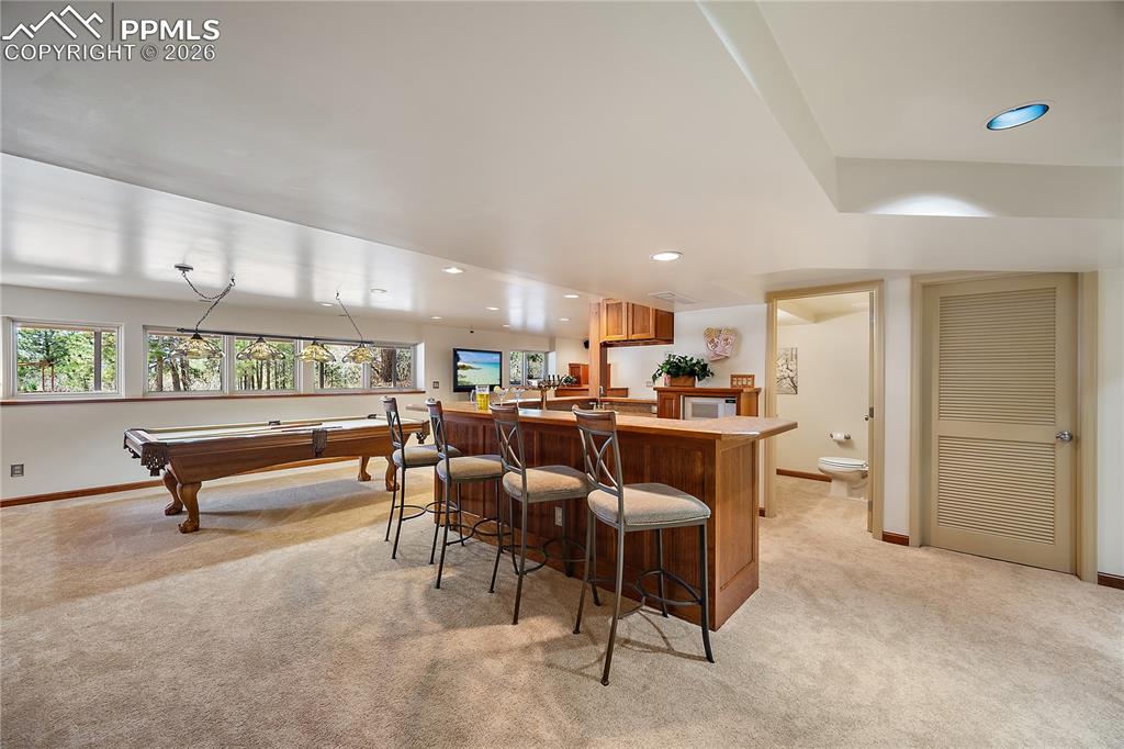 Image 32 of 49: Rec room with wet bar.