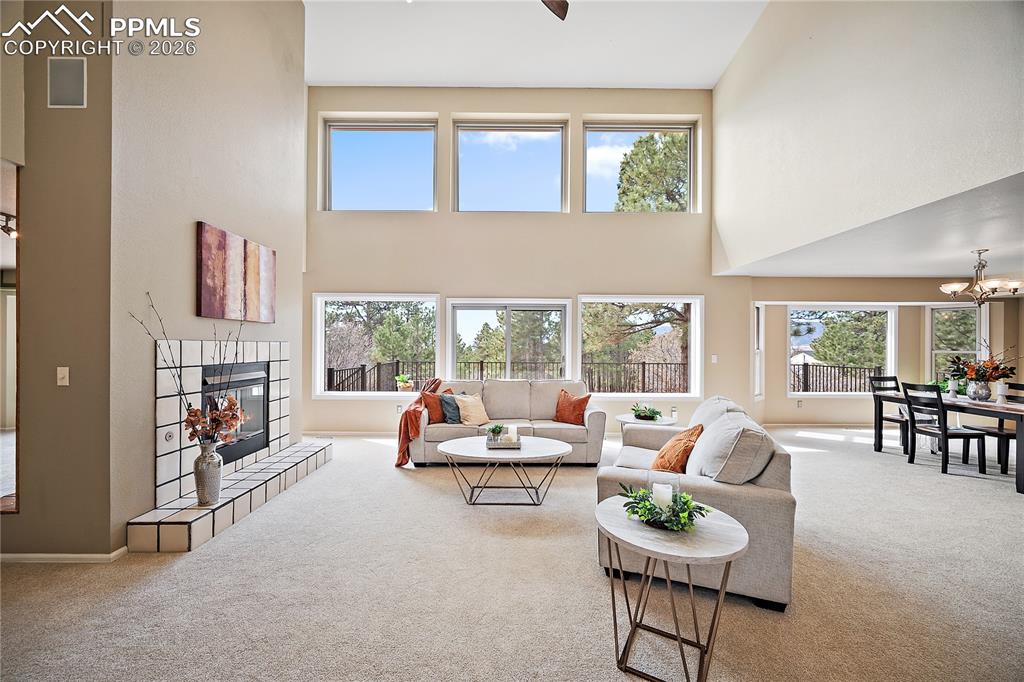 Image 8 of 49: Living room with 2 story ceiling and a a wall of windows that feature gorge