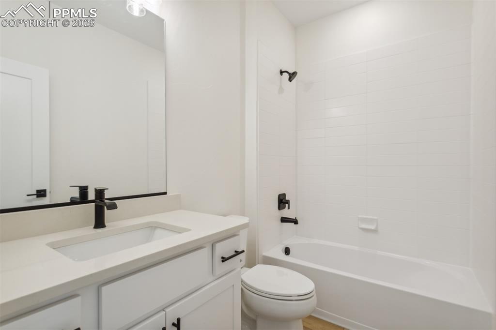 Image 14 of 22: Bathroom with toilet, vanity, and bathtub / shower combination