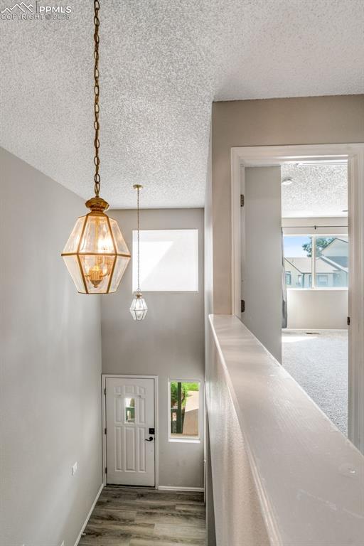 Image 10 of 30: Foyer featuring a textured ceiling, wood finished floors, and a high ceilin