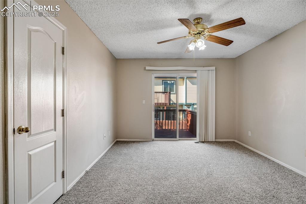 Image 11 of 30: Primary bedroom with a ceiling fan and a patio