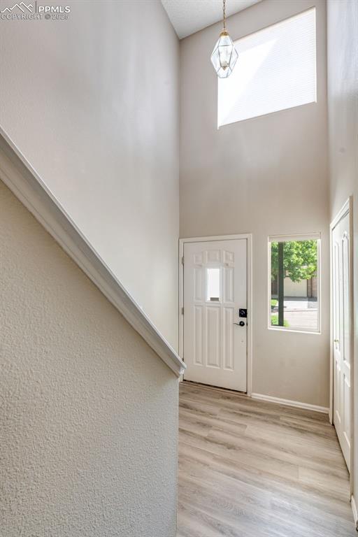 Image 2 of 30: Entryway with light wood-style flooring and a high ceiling
