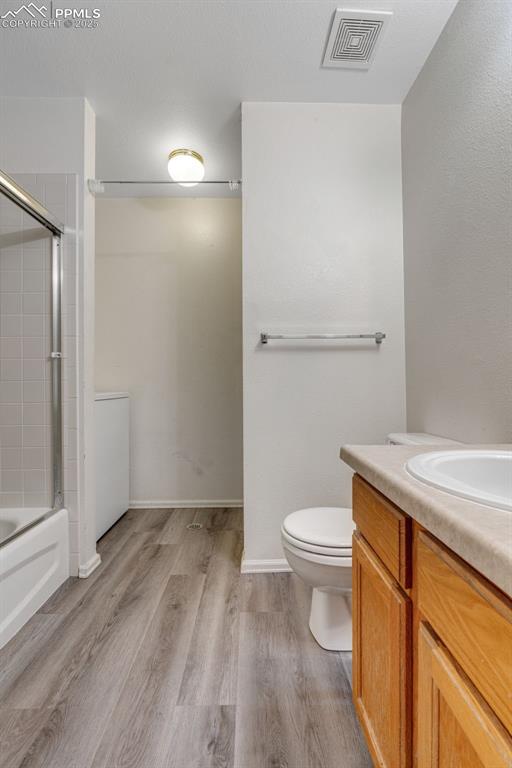 Image 20 of 30: Full bathroom with vanity, combined bath / shower with glass door, and ligh