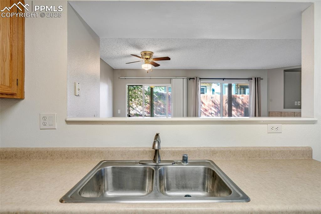 Image 4 of 30: Kitchen featuring light countertops, a textured ceiling, a textured wall, a