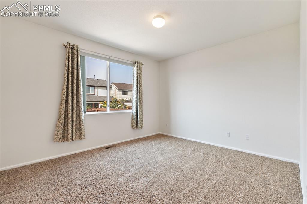 Image 13 of 28: Large, main level master bedroom with en suite bath and walk-in closet.