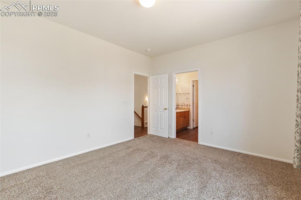 Image 14 of 28: Large, main level master bedroom with en suite bath and walk-in closet.