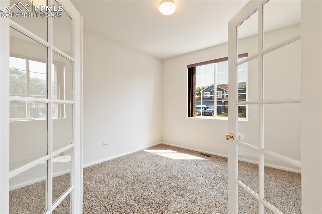 Image 7 of 28: Bedroom, or home office, with french doors and walk-in closet.