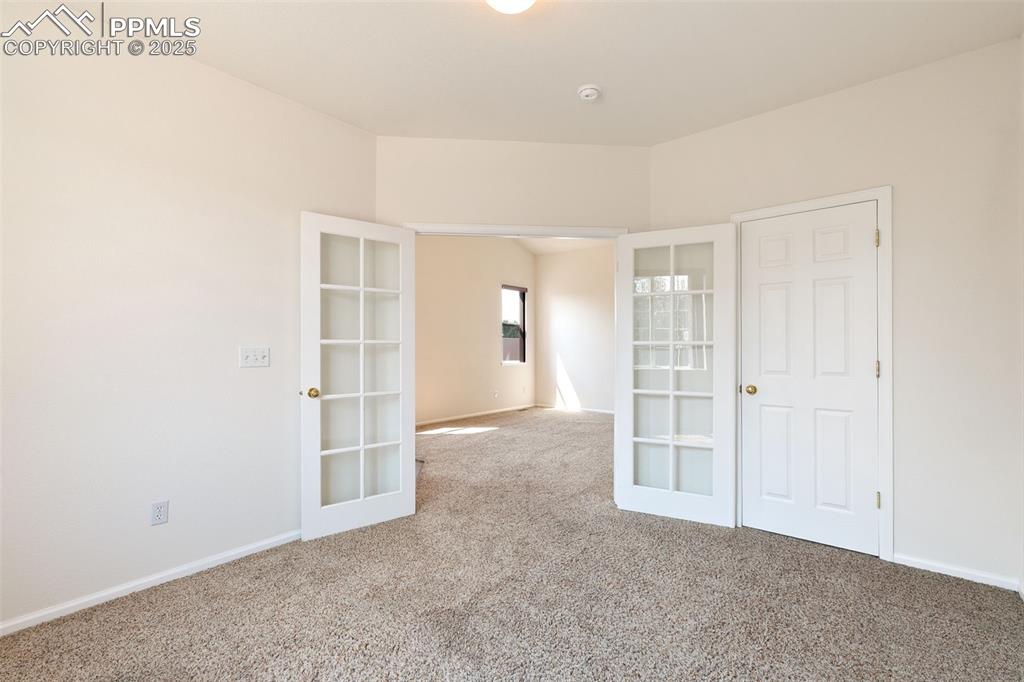 Image 8 of 28: Bedroom, or home office, with french doors and walk-in closet.