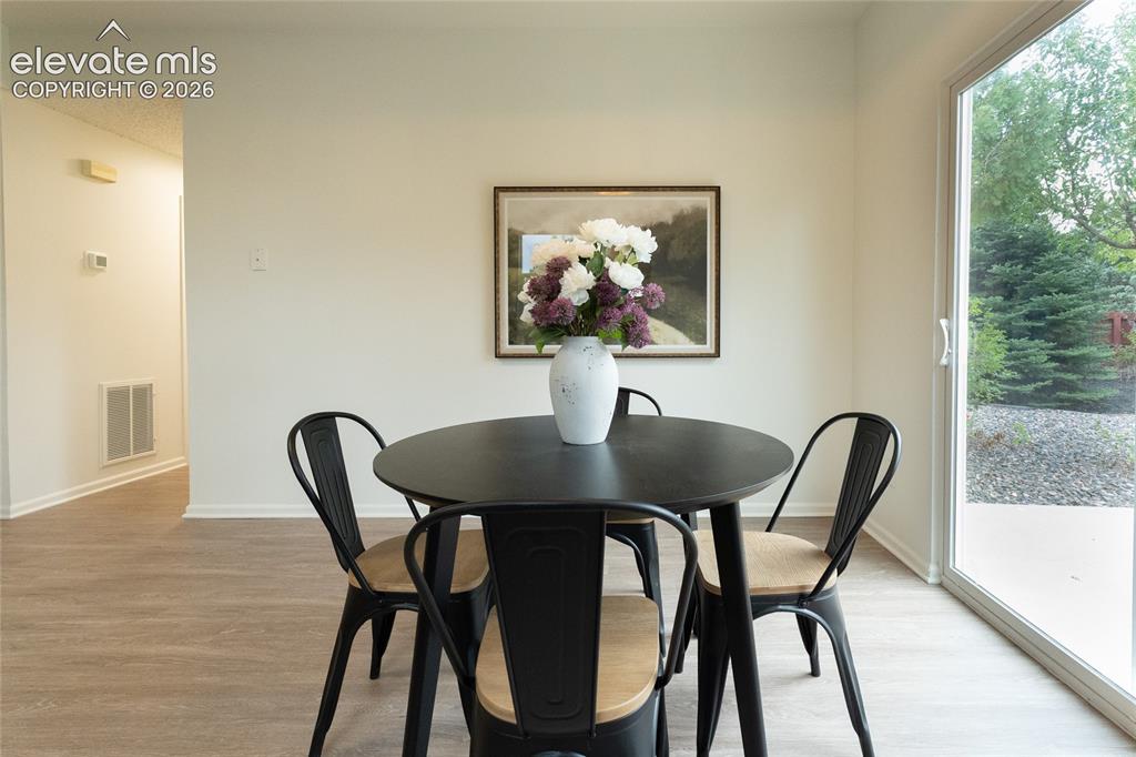 Image 10 of 26: Wood-finish flooring, white wall paint, sliding glass door, and outdoor lan