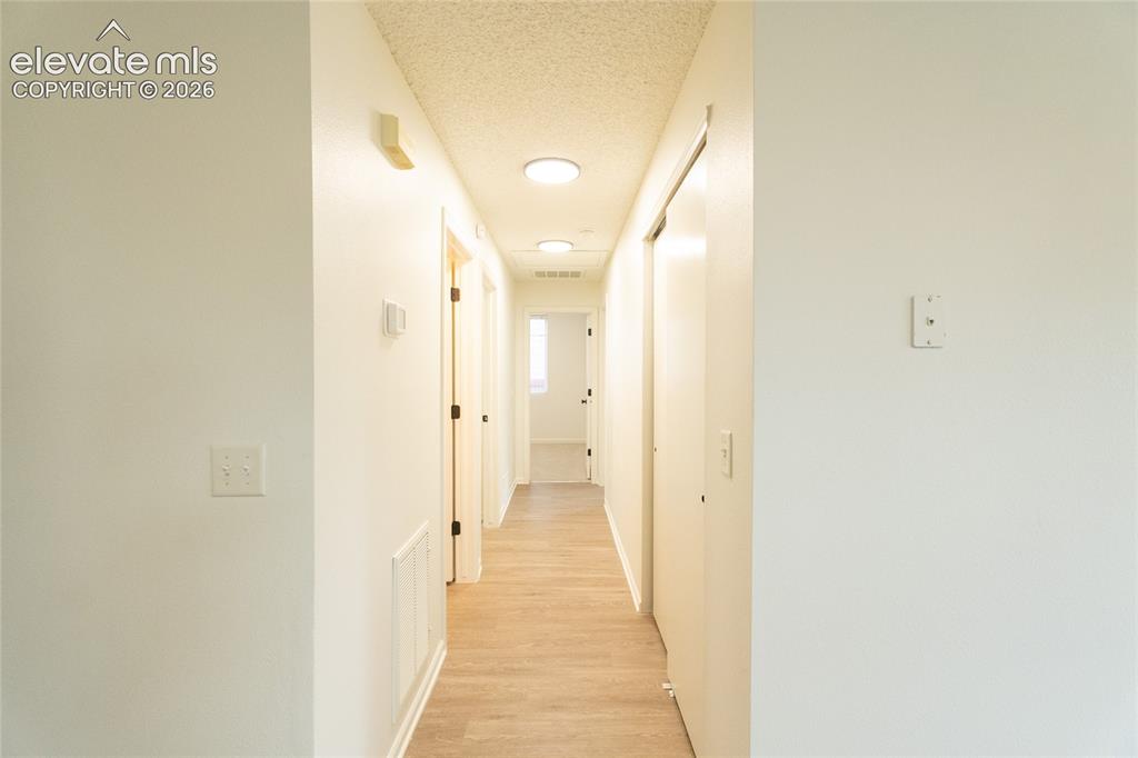 Image 11 of 26: Corridor featuring wood-finish flooring, recessed lighting, and white walls