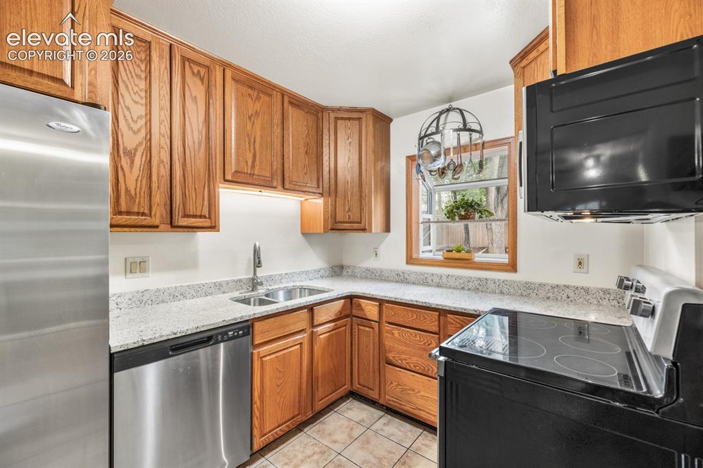 Image 10 of 32: Stainless steel Dishwasher and Refrigerator plus a sunny plant window