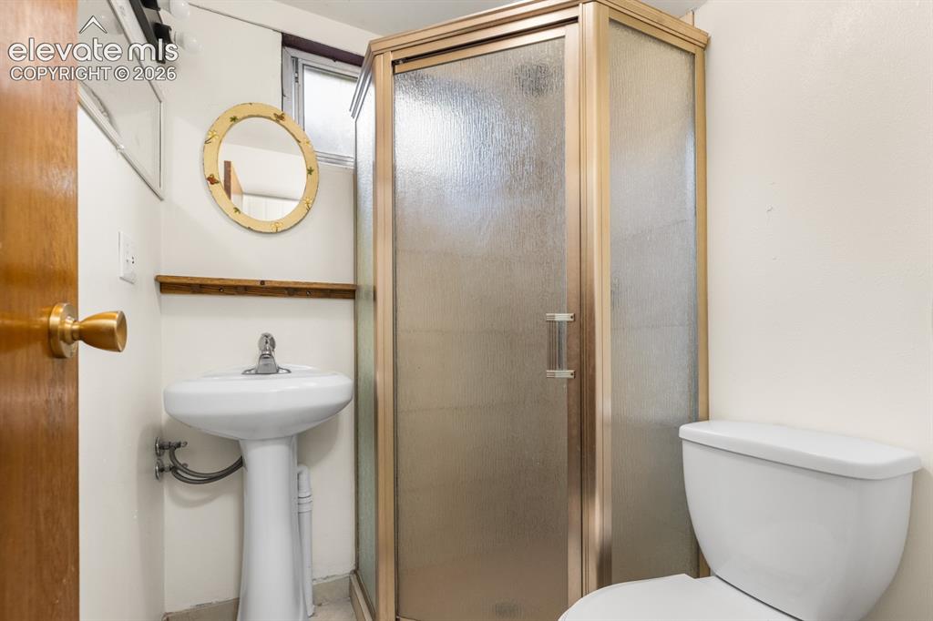 Image 19 of 32: Basement 3/4 bathroom featuring a pedestal sink and walk-in shower