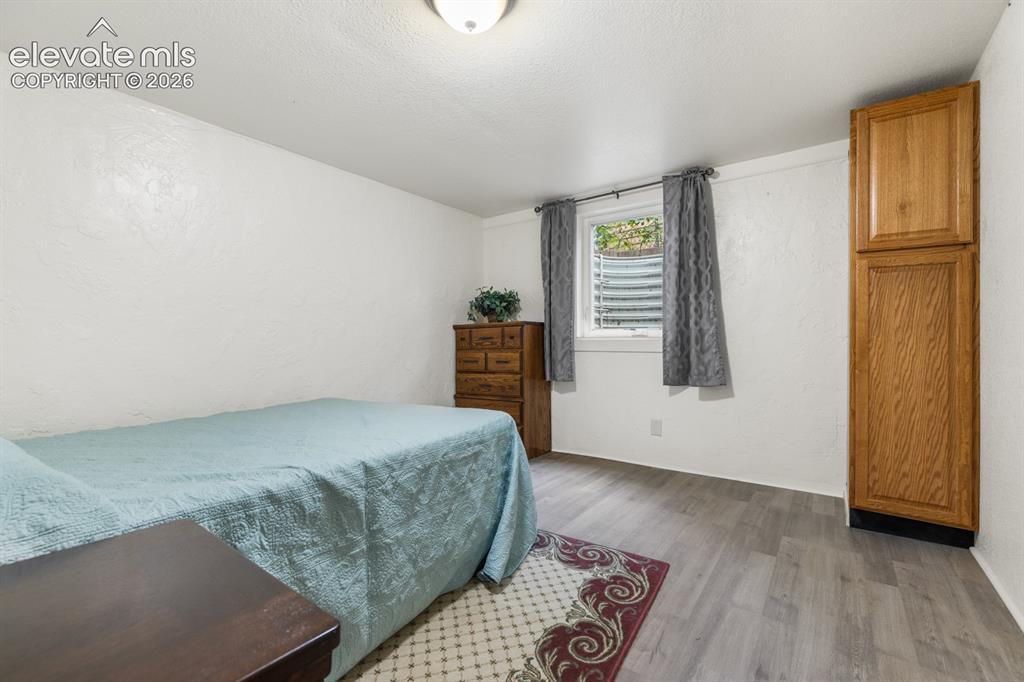 Image 21 of 32: Bedroom #4. Clothing storage space is a cabinet. Th4 window and window wel