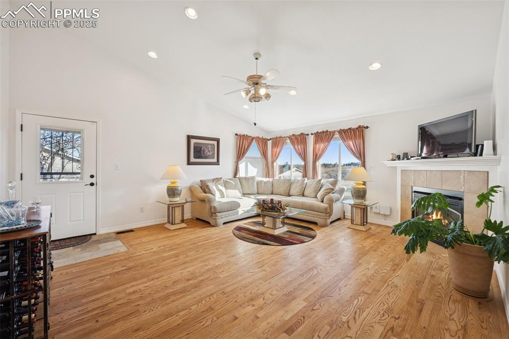 Image 28 of 45: Cozy living room with vaulted ceilings and gas fireplace. Walk-out on to ba