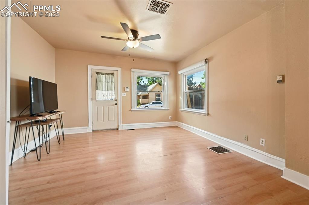 Image 10 of 24: Unfurnished living room with light wood-style flooring and ceiling fan