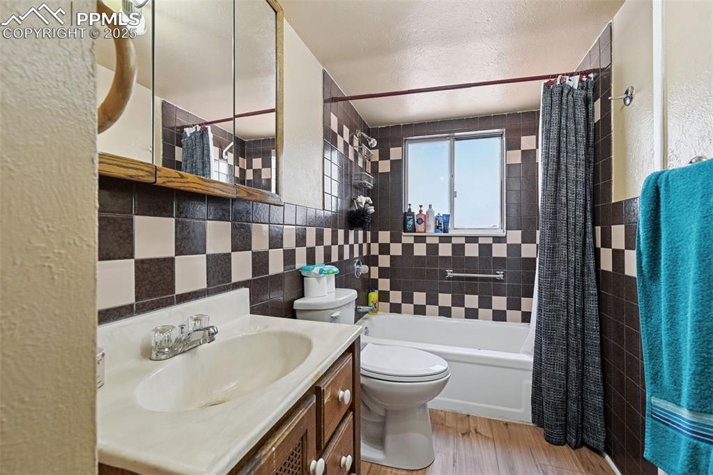 Image 15 of 24: Full bathroom with shower / bath combination with curtain, light wood finis