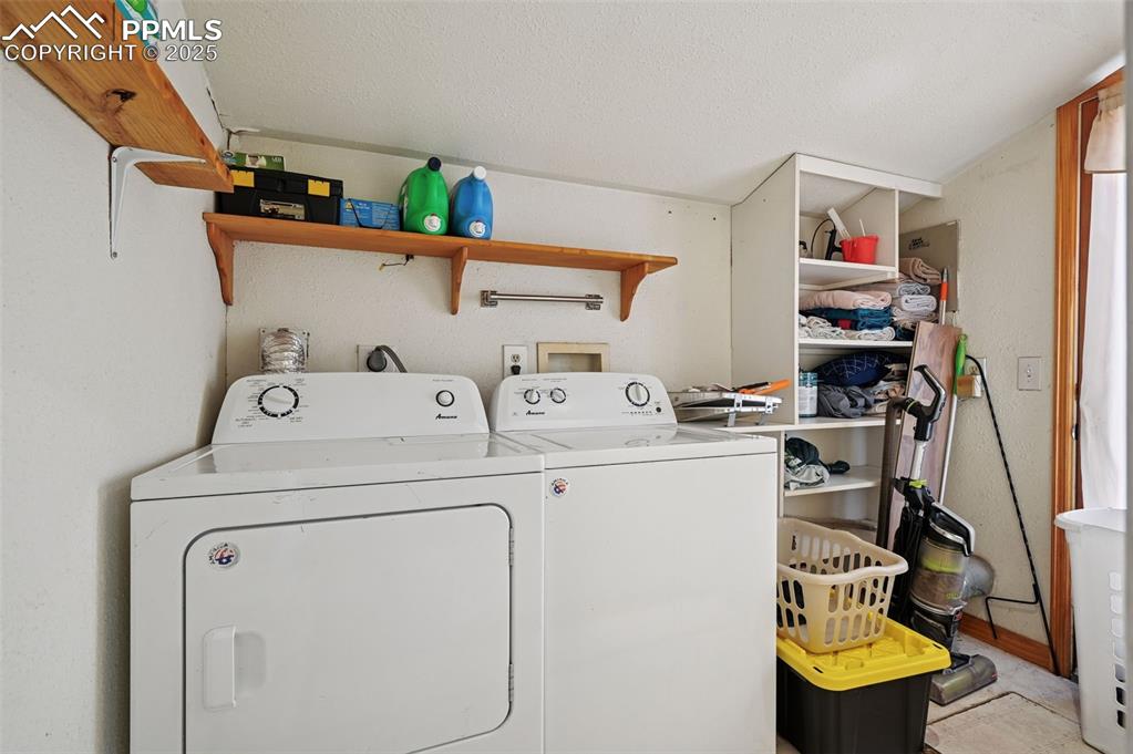 Image 16 of 24: Laundry area with washer and clothes dryer and a textured ceiling