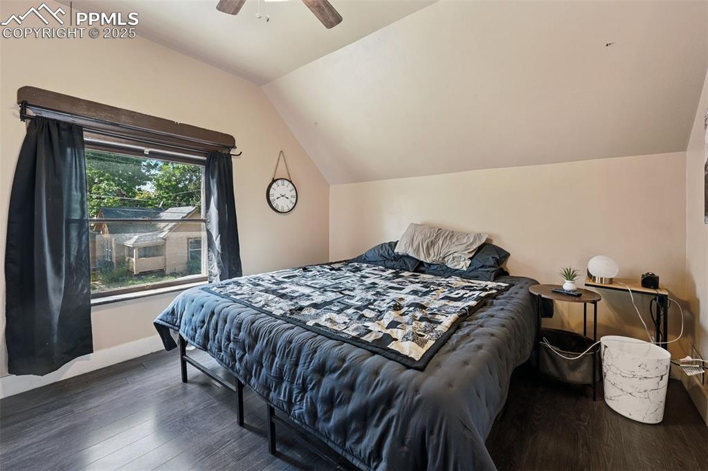 Image 17 of 24: Bedroom featuring dark wood finished floors, vaulted ceiling, and a ceiling