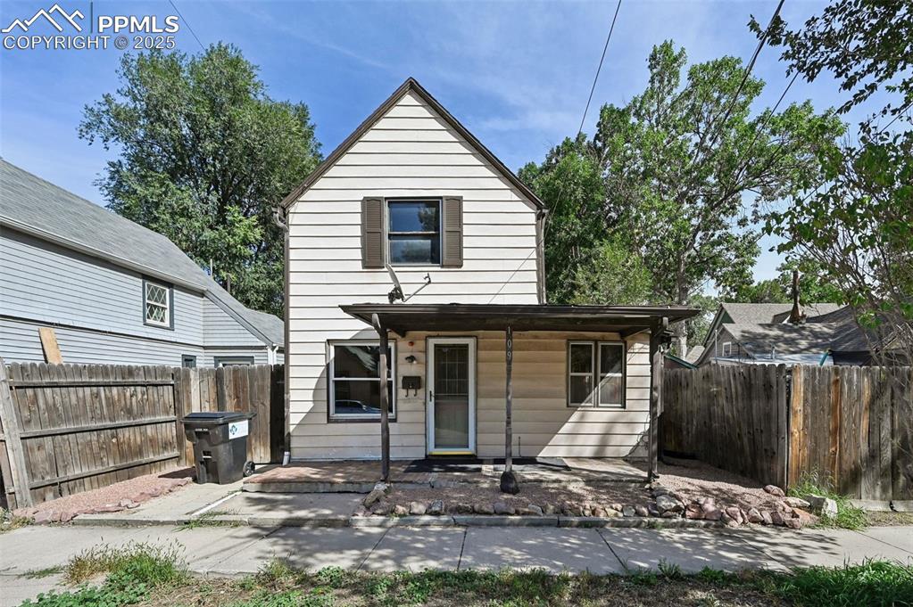 Image 2 of 24: Rear view of house featuring a fenced backyard and covered porch