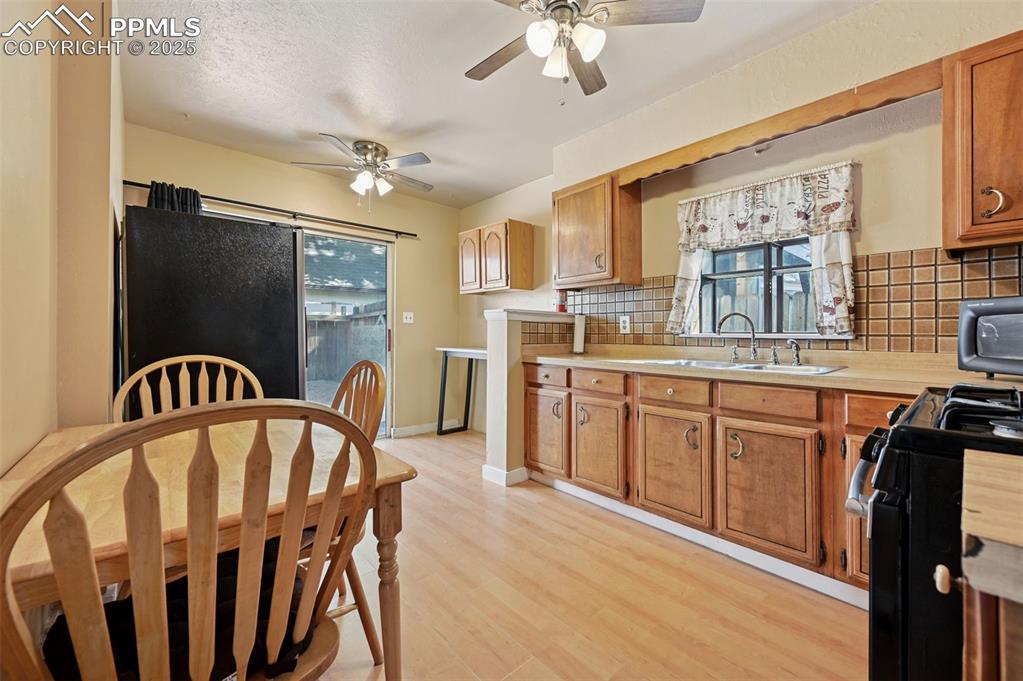 Image 4 of 24: Kitchen featuring gas stove, light countertops, light wood-type flooring, b