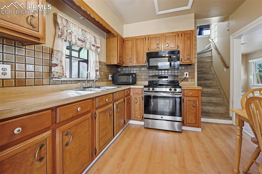 Image 6 of 24: Kitchen featuring tasteful backsplash, stainless steel gas stove, healthy a