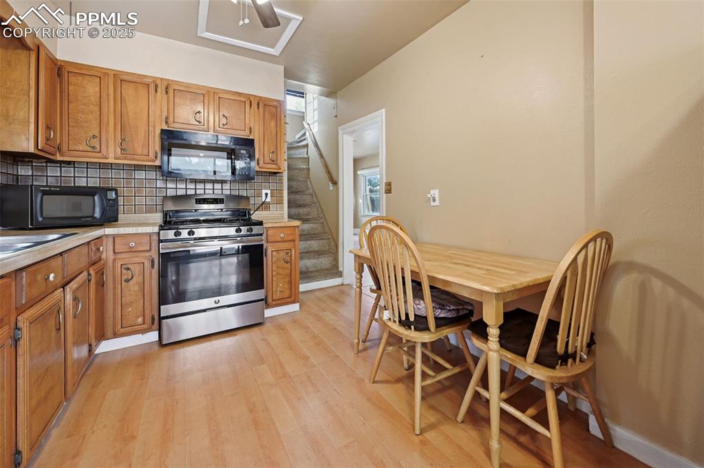 Image 7 of 24: Kitchen featuring stainless steel gas range, tasteful backsplash, light cou