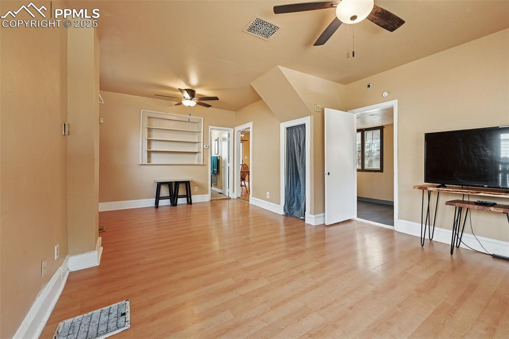 Image 8 of 24: Unfurnished living room featuring light wood-style flooring and ceiling fan