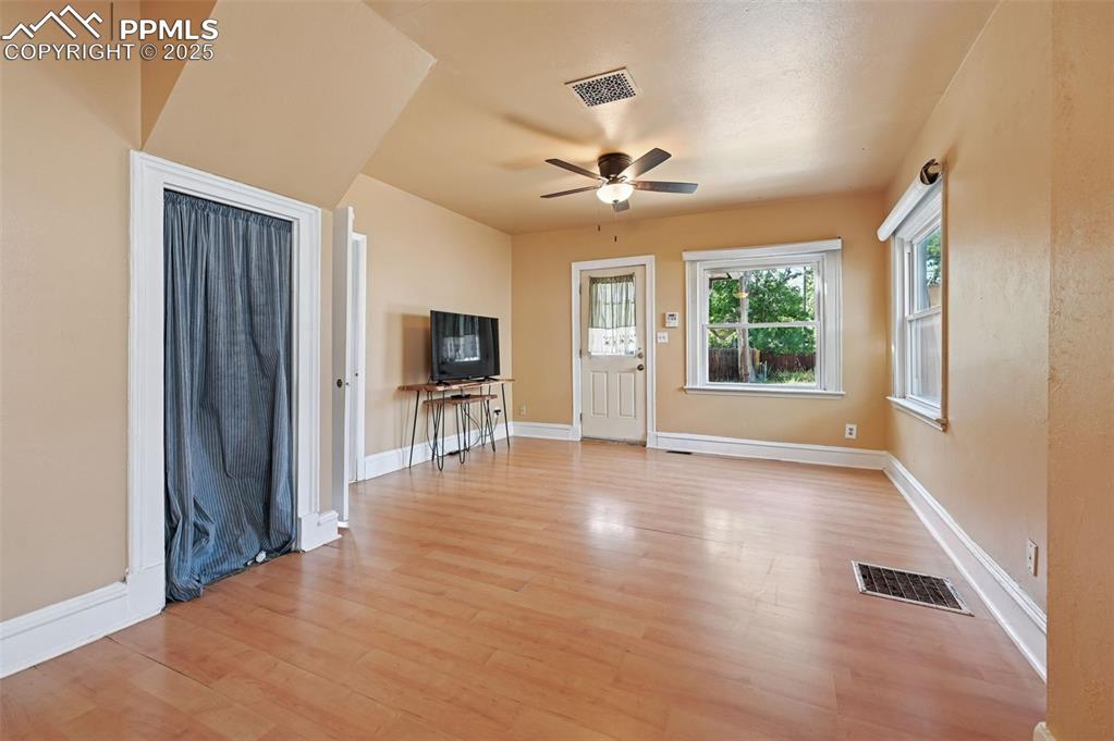 Image 9 of 24: Unfurnished living room with light wood-style floors and ceiling fan