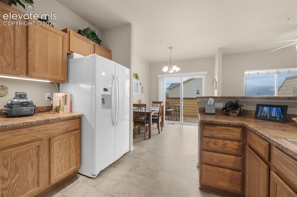 Image 12 of 28: Kitchen featuring wood cabinetry with under cabinet lighting