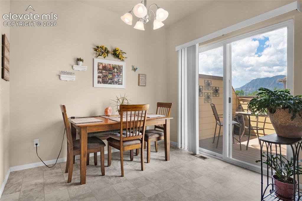Image 13 of 28: Sliding glass doors open to an outdoor deck with mountain scenery