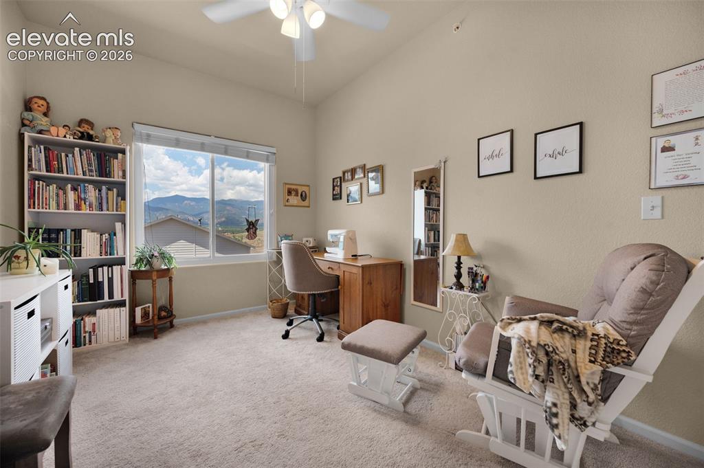 Image 19 of 28: Large bedroom #2 being used as a study. Carpeted with a vaulted ceiling and