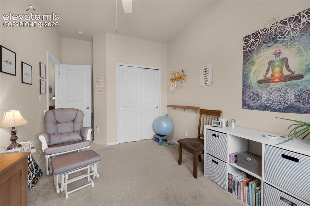 Image 20 of 28: Bedroom #2 being used as an office. Neutral-toned room featuring a vaulted