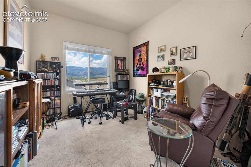 Image 21 of 28: Bedroom #3 being used as a music room. Light-colored walls and carpeting cr