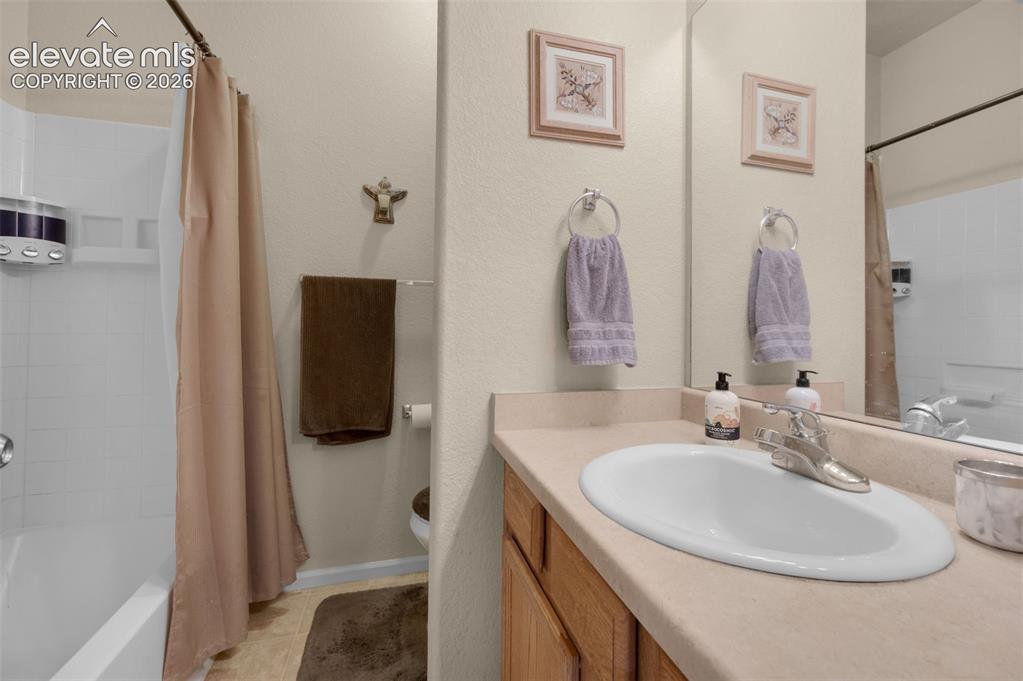 Image 22 of 28: Bathroom vanity with an integrated sink, polished chrome faucet, and a larg