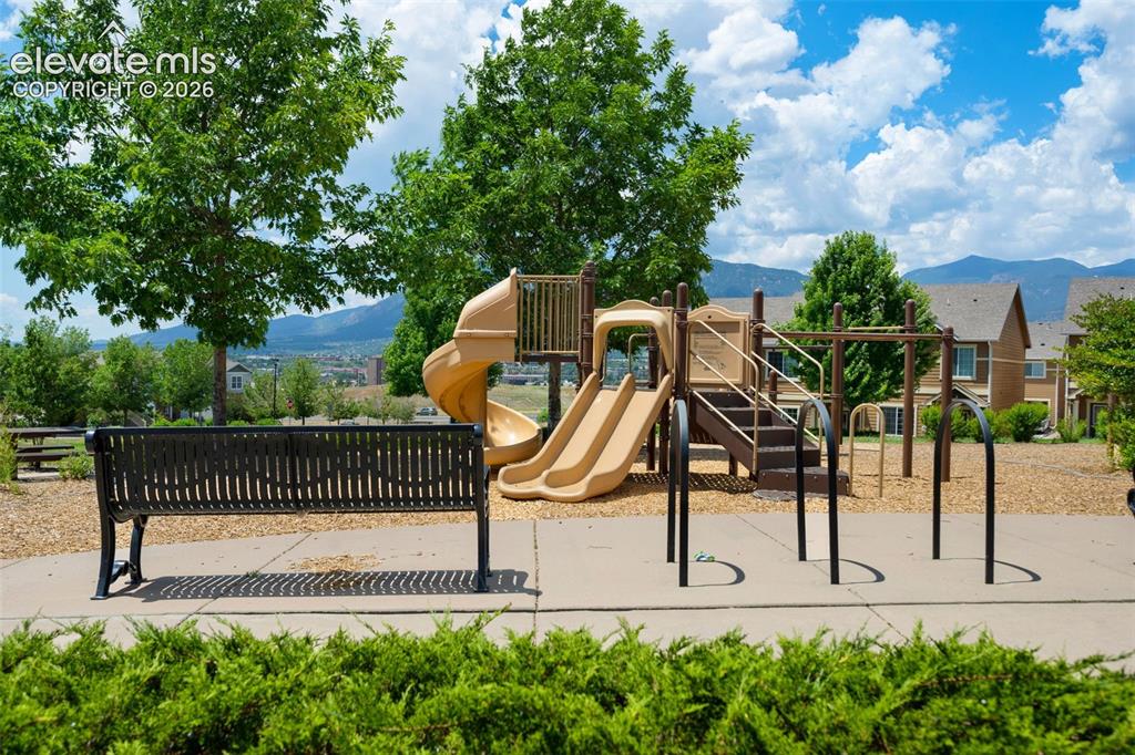 Image 24 of 28: Community playground featuring multiple slides, climbing structures, and sw