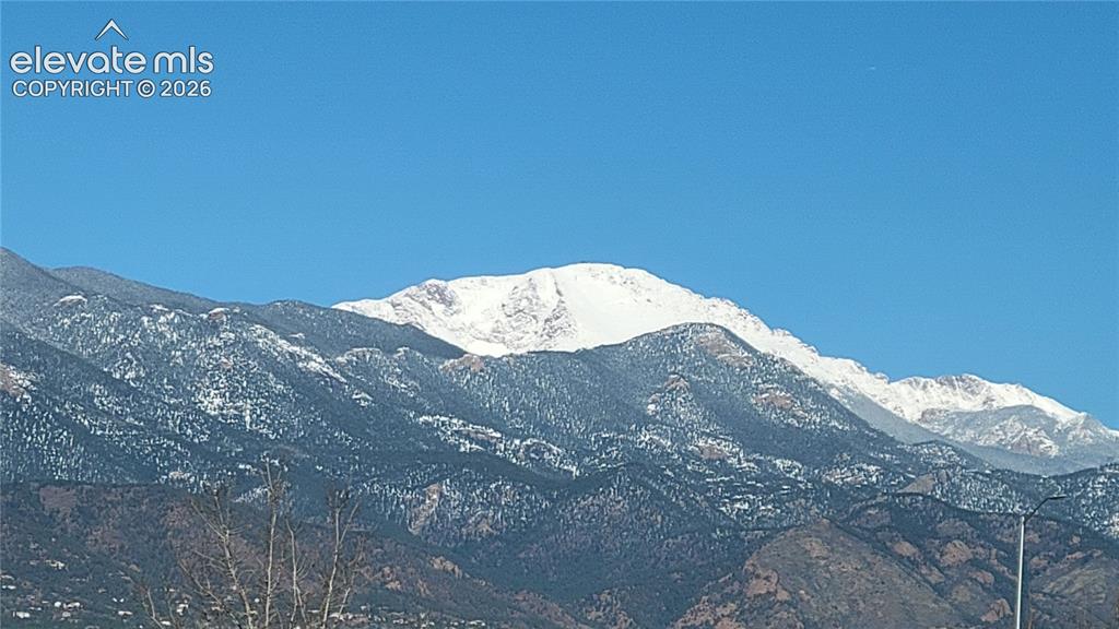 Image 26 of 28: View of a snow-capped Pikes Peak under a clear blue sky from the deck