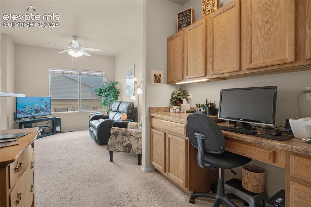 Image 8 of 28: Dedicated office space featuring built-in wood cabinetry, a coordinating co