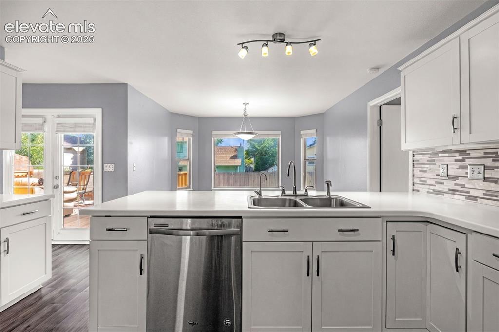 Image 12 of 49: Open-concept kitchen featuring white shaker cabinetry, an integrated stainl