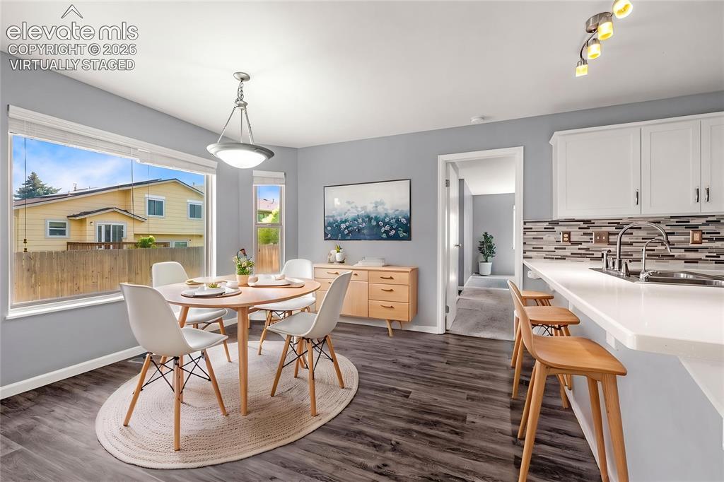 Image 13 of 49: Dining area featuring large windows, wood-finish flooring, a contemporary p